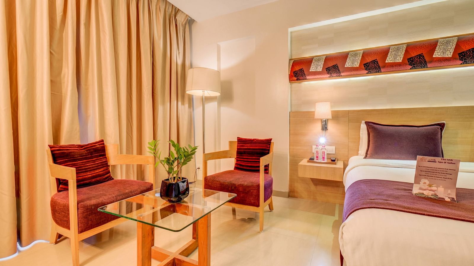 a view of the seating area with bed at deluxe room at SSK Solitaire Hotel And Banquets