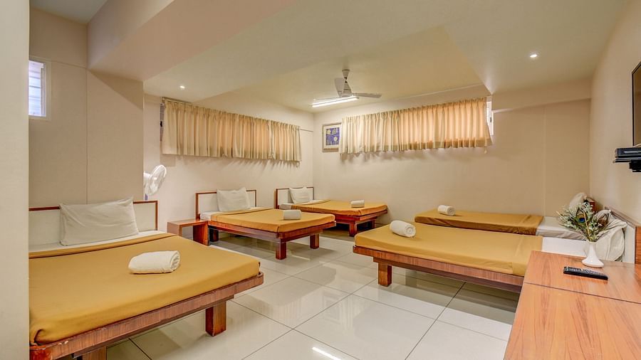 A spacious room with neatly made single beds at Hari Govinda’s JN Stay, Shakthinagar