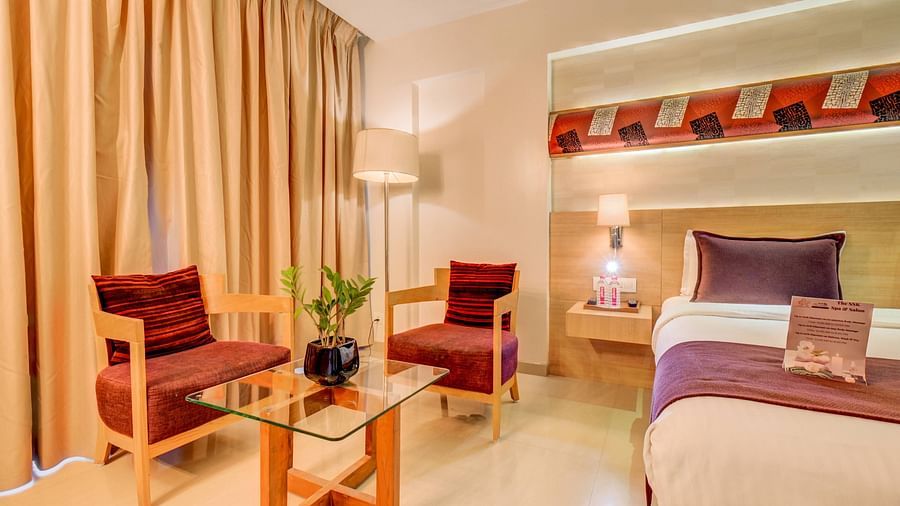 a view of the seating area with bed at deluxe room at The SSK Solitaire Hotel & Banquets, Mumbai Naka - Nashik