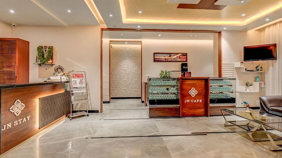 The reception area at Harigovinda's JNStay, featuring two desks and warm lighting
