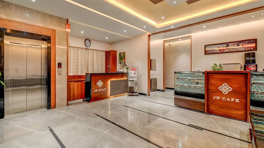 The reception area at Harigovinda's JNStay, featuring two desks and a lift to the side
