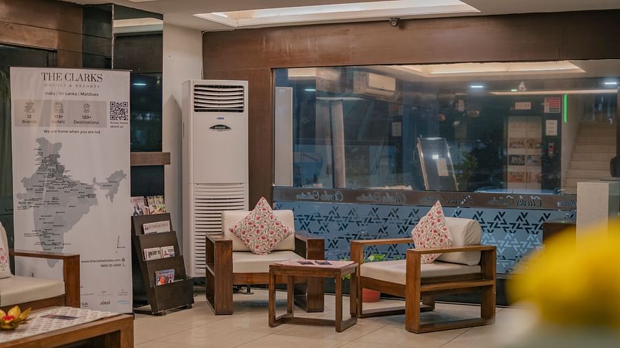 The lobby seating area with chairs and a large window at Clarks Collection, Vadodara.