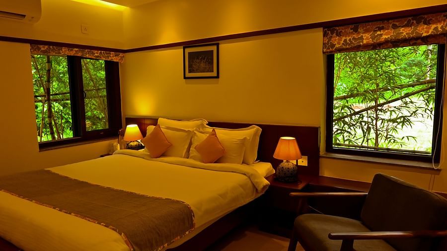 Sunset Villa BEDROOM with a comfy kind size bed and open window with greenery around the villa 