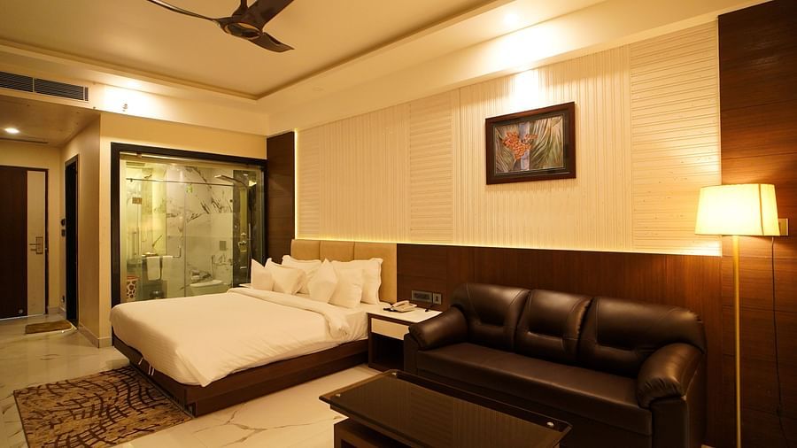 a double bed with a sofa, a coffee table and a lamp next to the sofa inside one of the rooms - Shanti Seaview Resort & Spa - Mandarmani Hotel Sea Facing