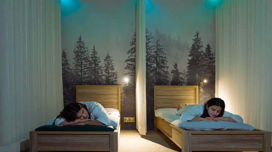 Tranquil quiet room with twin massage beds, forest mural backdrop, and ambient lighting at The Manor Wellness & Sports Hotel