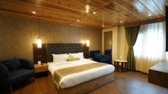 King size bed in room with wooden floor and curtained windows at Mount Magnolia Boutique Hotel and Spa.