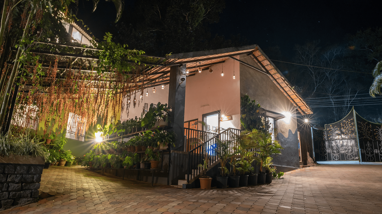 Night facade of an accommodation with an open area in front at Coorg Jungle Camp Backwater Resort, Kushalnagar. 