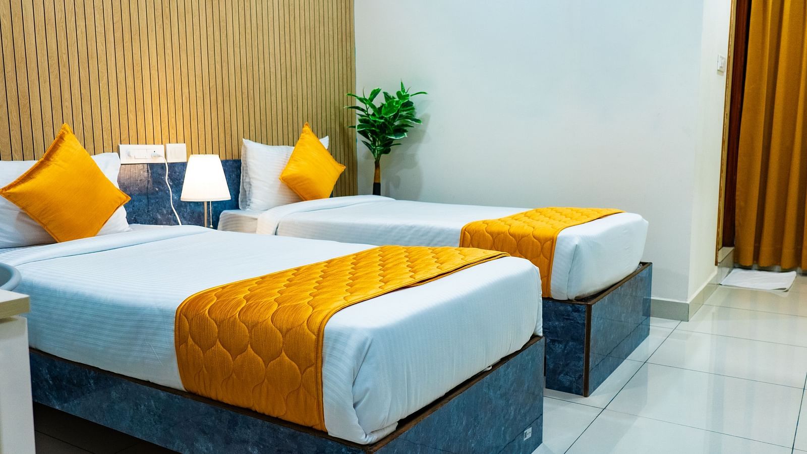 An image of a bedroom with twin bed, bedside table next to it, AC, etc. - Hotel Aerotel, Hyderabad - A Unit of Comfort Hometel
