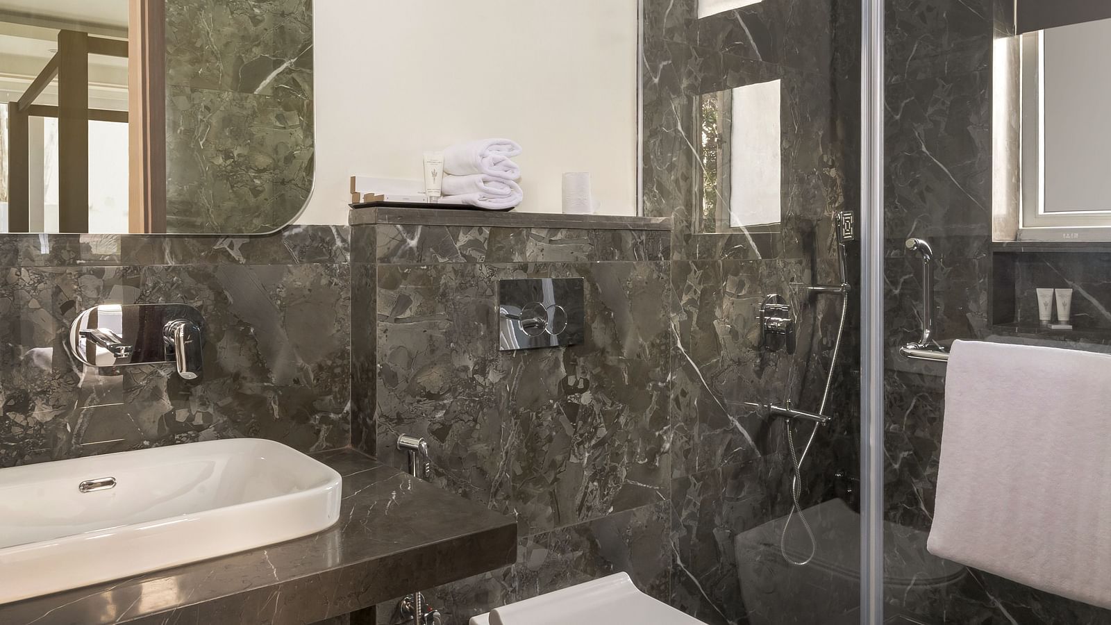 An overview of a bathroom with shower area in view in one of the rooms - The Tanisi Hotels & Resorts, Goa