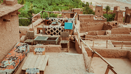 a mud terrace with seatings and greenery in the background.