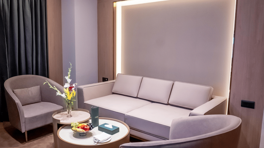 Living area with sofa, chairs and a window with a curtain in the background at ASTER GRAND BY ZENQ SAKET.