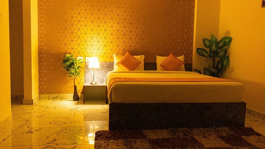 An image of a bed where only a table lamp is lit next to it - Hotel Aerotel, Hyderabad- A Unit of Comfort Hometel