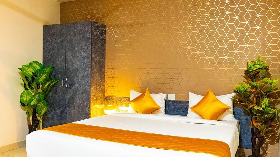An image of bedroom that has a king size bed and a wardrobe table next to it - Hotel Aerotel, Hyderabad - A Unit of Comfort Hometel