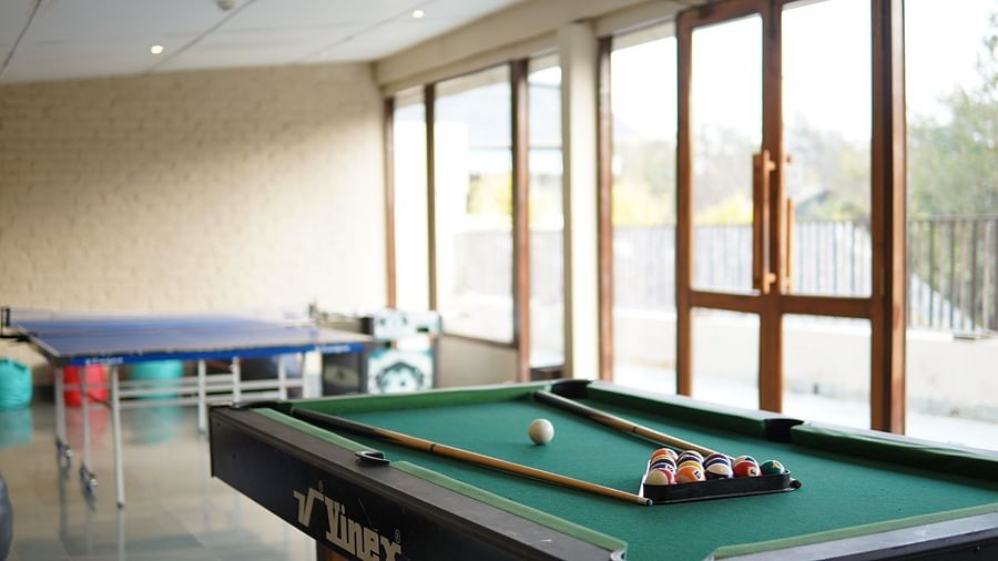 Indoor play area at Saraca Resort & Spa Corbett with a table tennis and a pool table and large windows