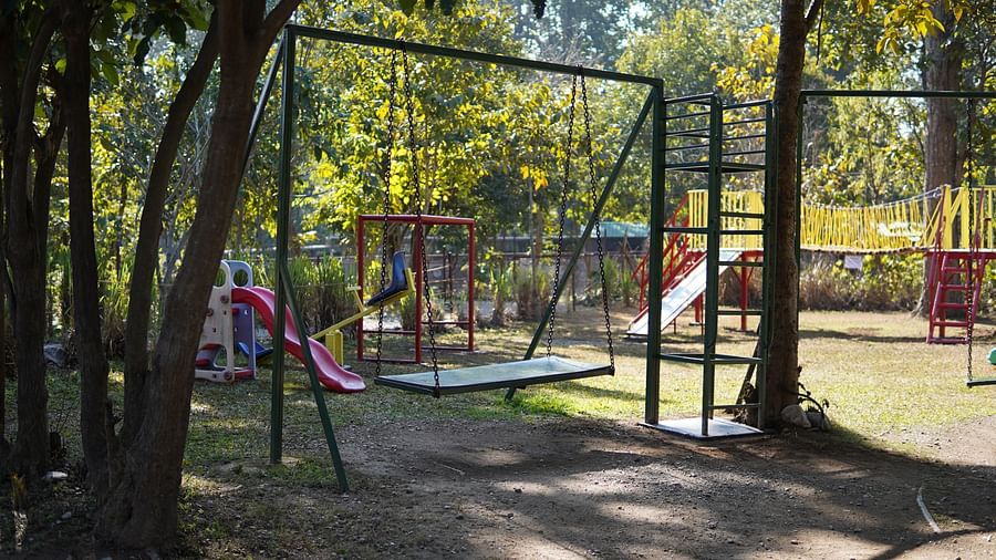 A swing in the Kids Play Area at Saraca Resort & Spa Corbett with trees in the backdrop