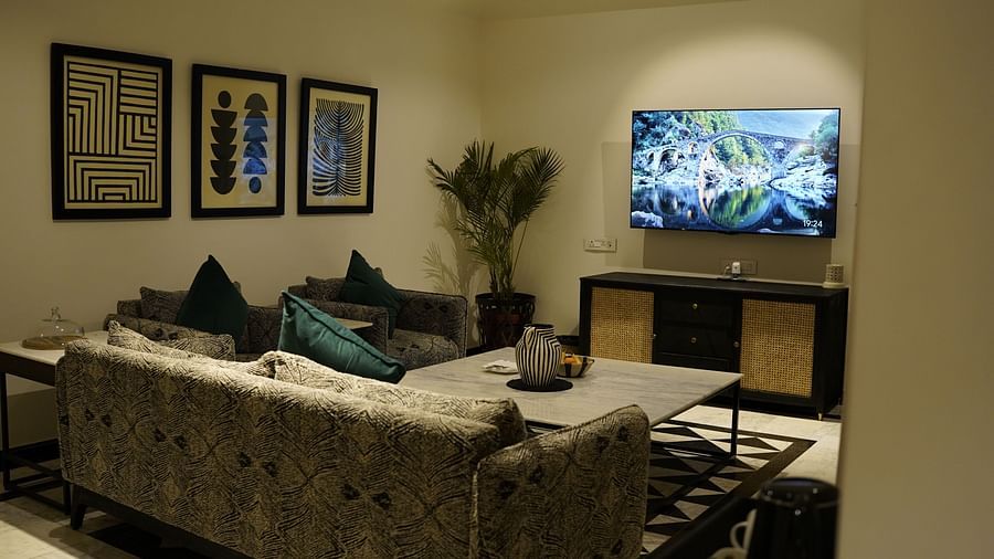 Back view of a seating area with a sofa and a television in front at Surpura Bagh.