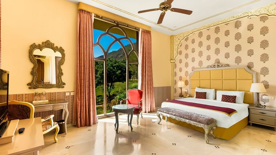 An overview of a room with a double bed, side tables and ceiling fan in view - Rajasthali Resort & Spa, Jaipur.