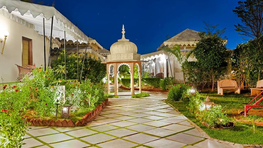 A tiled pathway leading to a canopy with potted plants on either side - Rajasthali Resort & Spa, Jaipur.