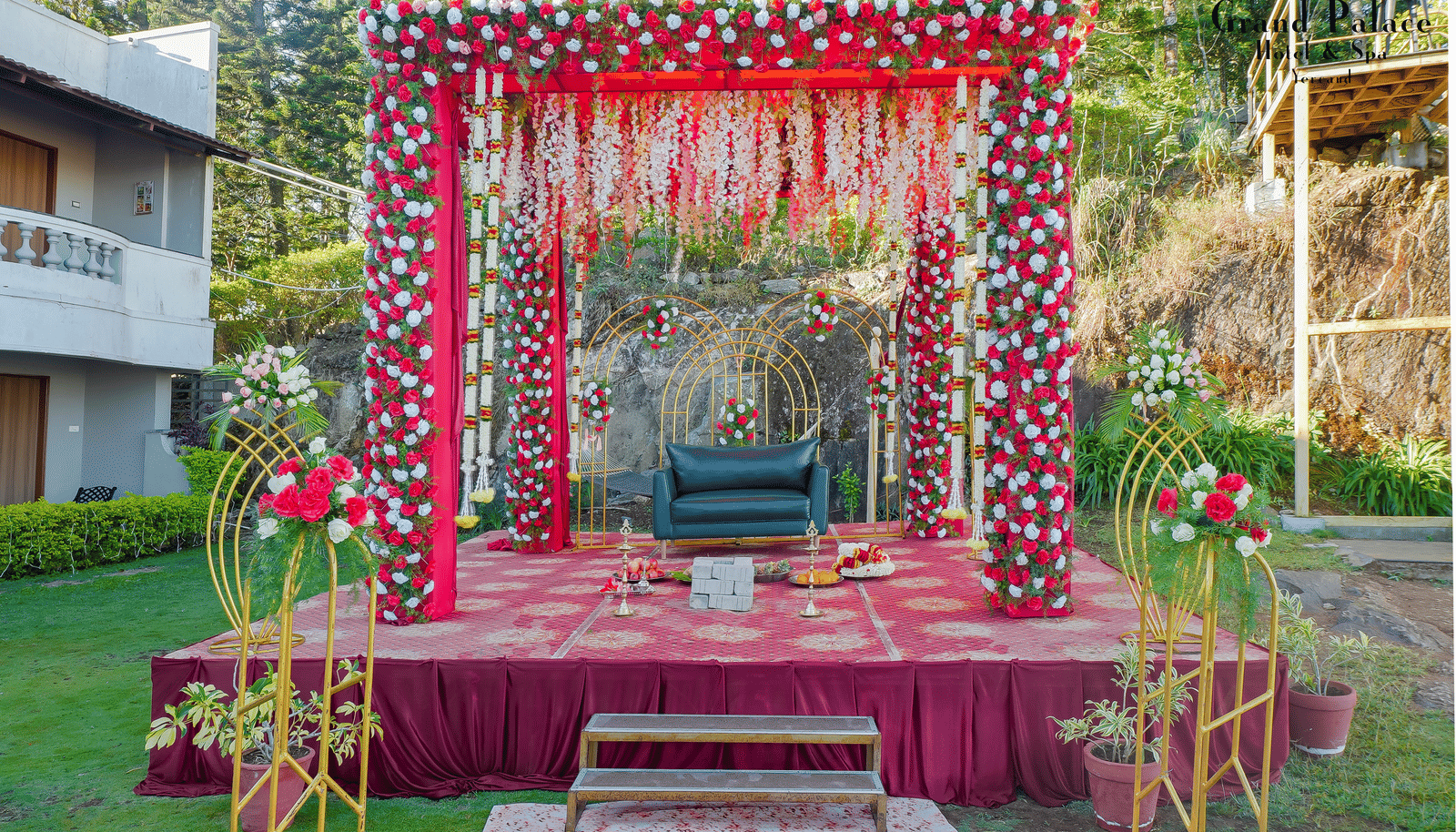 Outdoor wedding stage at Grand Palace, Yercaud with floral backdrop, chairs, steps, walkway, floral decorations, and garden area ready for ceremony.
