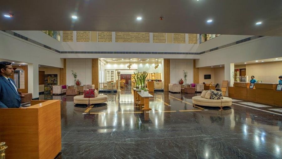 Wide view of the hotel lobby with seating and reception area at Golden Tulip, Udaipur.