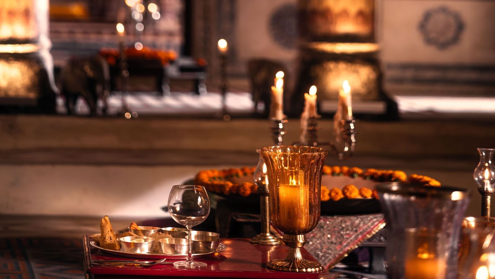 Ornate arches and warm lighting are reflected in a large mirror at Fort Barli, creating a layered and atmospheric interior view.