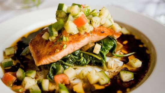 A fish fillet garnished with sauce and vegetables - Stone Wood Riverfront Resort, Siolim