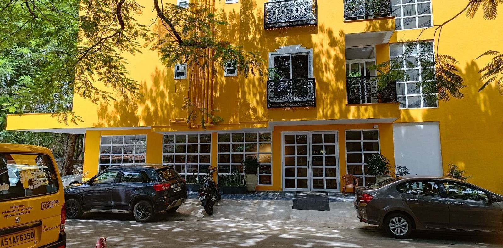 facade image of Astra Hotels and Suites in Koramangala with a bright yellow coloured exterior and beautiful windows
