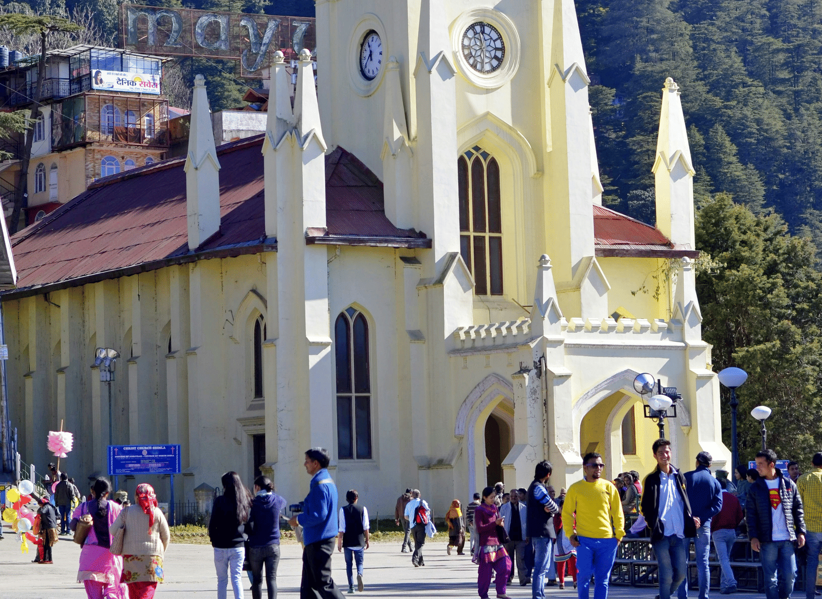 A church with people walking in front of it on the road.