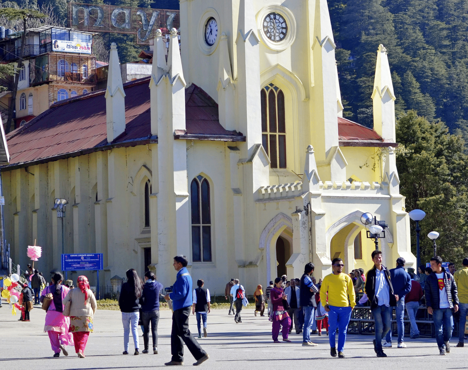 A church with people walking in front of it on the road.