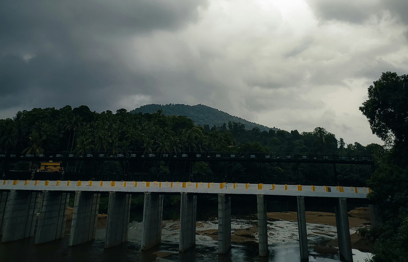 An image of dark clouds and hills view from bridge.