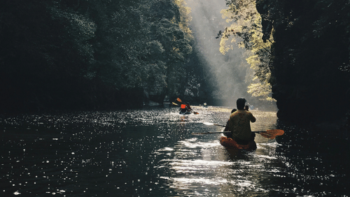 a group of people kayaking together amidst mountain cover on both sides