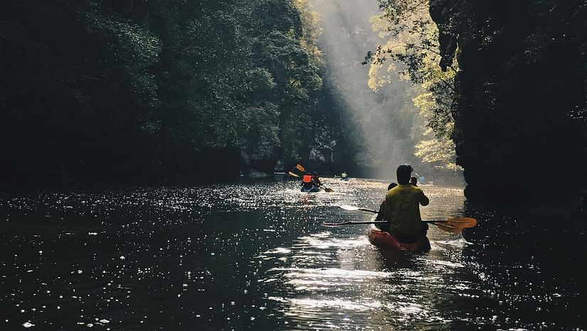 a group of people kayaking together amidst mountain cover on both sides