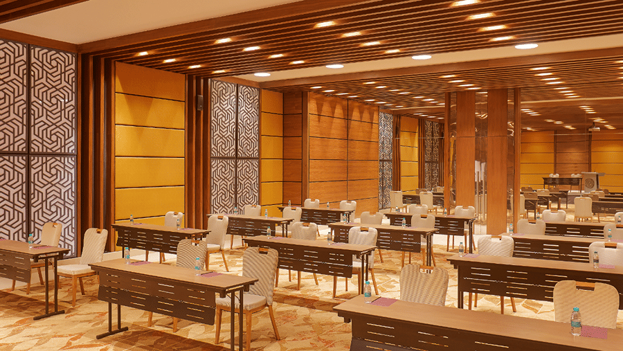 A close  side angle view of the Premier Banquet Hall at Residency Tower, Chennai, showcasing a royal interior design. The room features elegant decor with rich colors and intricate details. Classroom-style seating is arranged with tables and chairs, creati