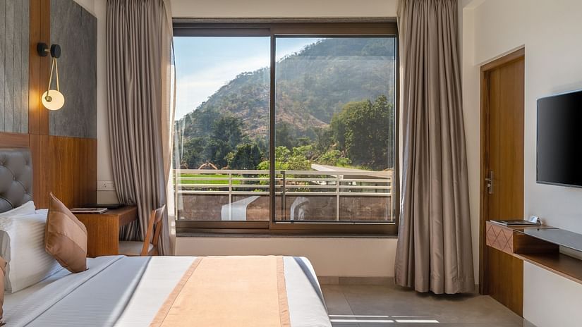 Enjoy the comfort of a king size bed and the scenic view through the balcony of the Superior Room at Stone Wood Hotel, Kumbhalgarh. For more details, explore images of Stone Wood Premier Kumbhalgarh to visualize the perfect stay.