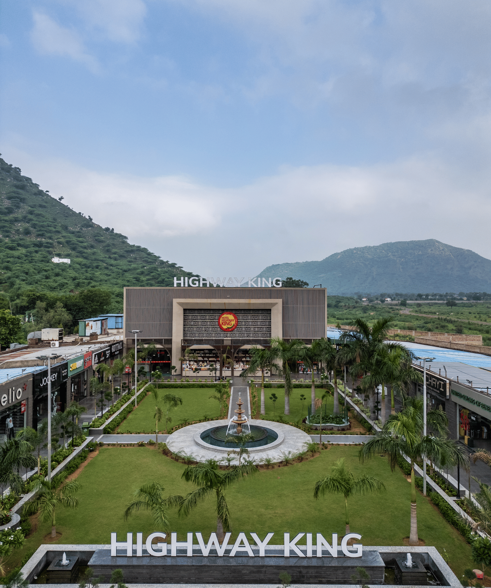 The main building entrance and formal landscape garden area at Hotel Highway King, Neelka.