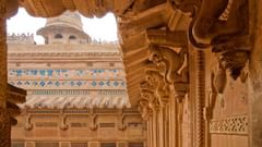 View of Gwalior Fort’s ornate carvings and architectural details framed by an intricately carved archway.