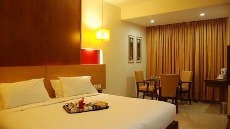 Luxury room with bed and seating area and bed at The Oriental Residency 