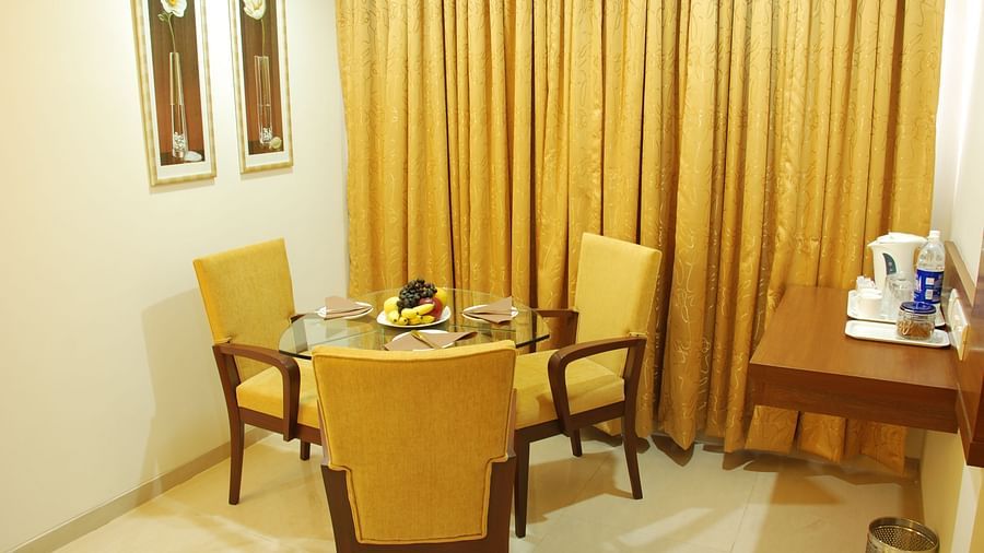 Sitting room of Luxury room with tables and chairs and frames on the wall at The Oriental Residency 