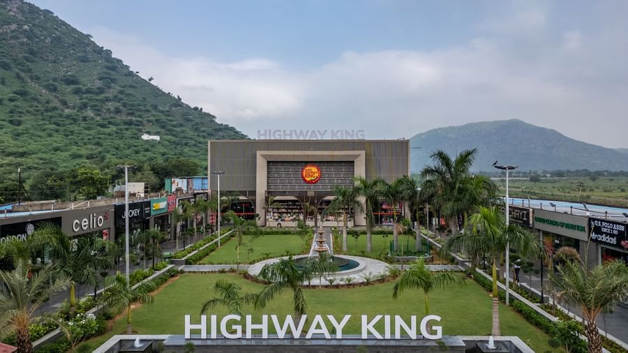 Facade view of Hotel Highway King, Neelka, with a lawn in front, set against mountains and a cloudy sky in the background at Hotel Highway King, Neelka.