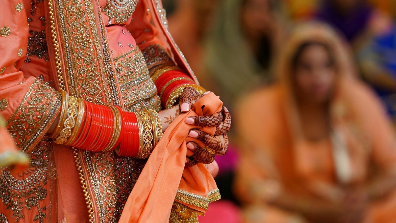 A close up shot of a henna stained hands with bangles