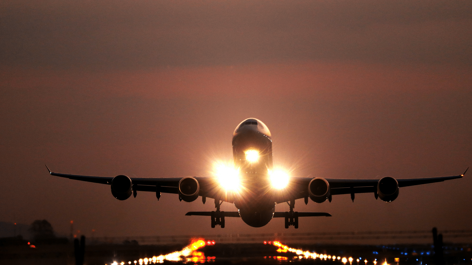 a plane taking off with lights on in the evening