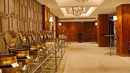 Buffet station with silver chafing dishes and ornate wall mirrors.