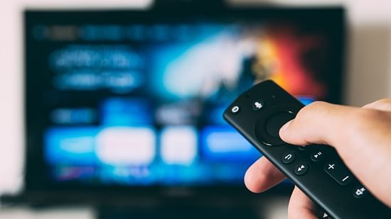 a man using remove to operate a television