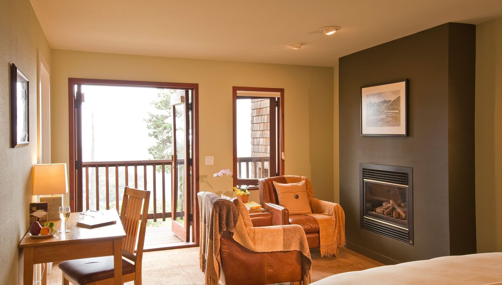 A spacious, elegant hotel room with large windows showcasing beautiful greenery outside, offering a tranquil and inviting atmosphere - Brewery Gulch Inn & Spa