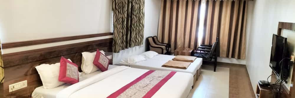 The Suite at Mountview Resort, furnished with two king size beds, a wall-mounted TV, air-conditioning, and a seating area.