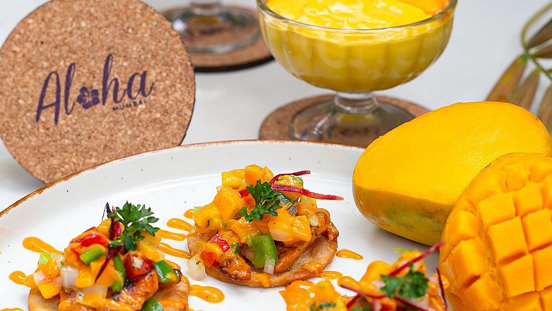 Mango dessert and tropical shrimp dish with an Aloha coaster at Hotel Mumbai House Mindspace, Malad.