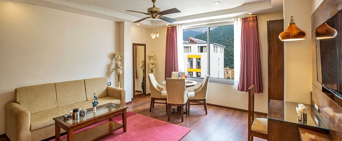 A brightly lit living area of the Suite at Regenta Inn DLS with ample of natural lighting coming form the window.
