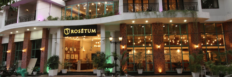 Facade of Rosetum Anjuna in the morning with a pavement in front of the hotel in view.