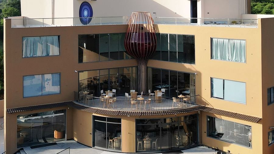 The Qualia Resort Club & Brewery, Udaipur with a terrace and outdoor seating is shown in daylight.