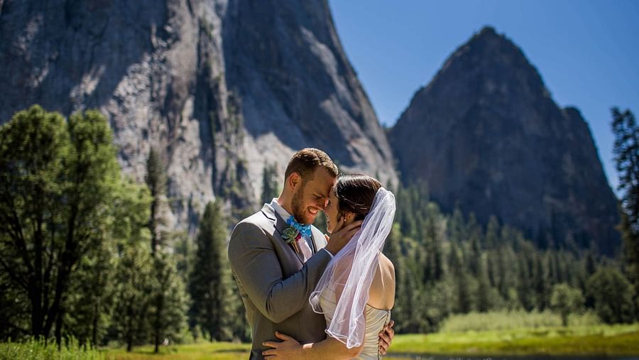A couple posing for a photoshoot with the Yosemite in the backdrop - Narrow Gauge Inn - A Serenite Hotel Near Fish Camp.